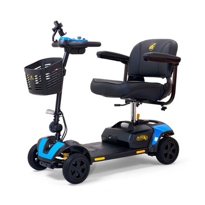 A robust heavy-duty mobility scooter, model 'Max 325,' featuring a sturdy frame, large tires, padded seat with armrests, and a spacious footrest. The scooter has a weight capacity of up to 325 lbs and is designed for outdoor use, shown on a paved path with greenery in the background.